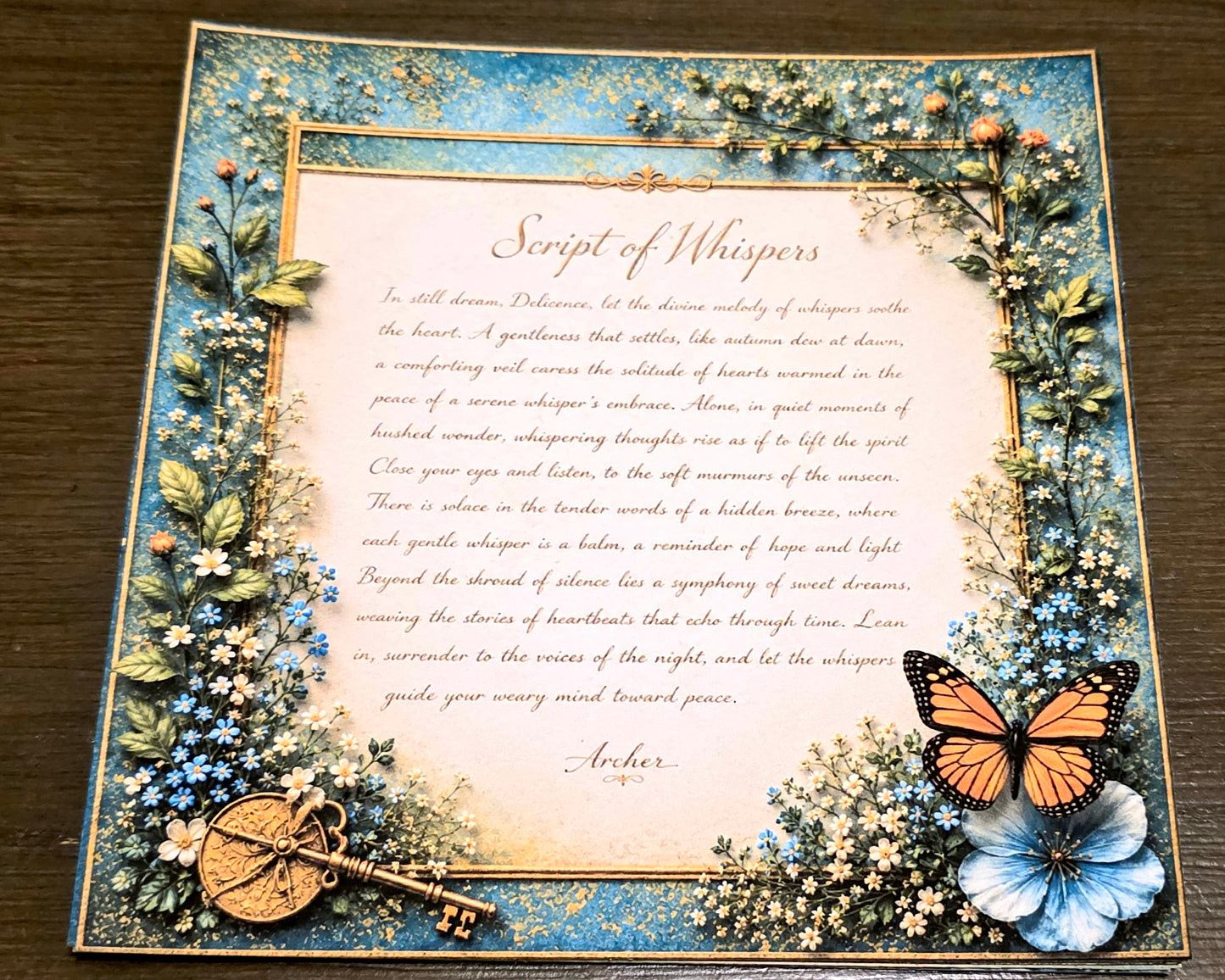 Decorative paper with floral frame, butterfly, key, and text on a wooden surface