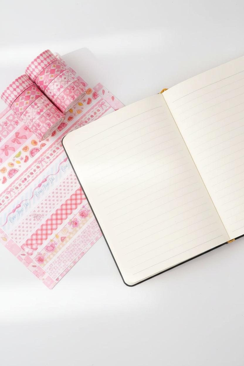 Stack of pink patterned tapes held by a hand on a colorful background