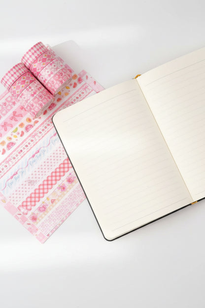 Stack of pink patterned tapes held by a hand on a colorful background