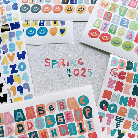 Colorful alphabet and number stickers with 'Spring 2025' text on a light gray background
