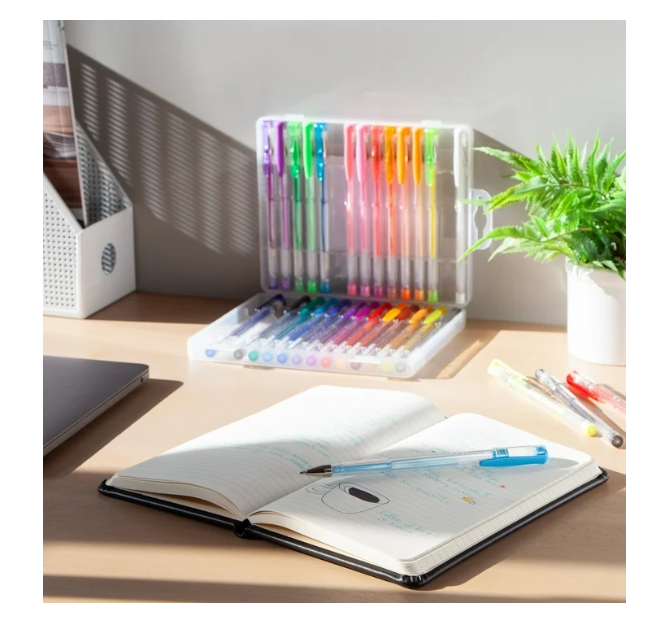Set of colorful pens in a transparent holder on a desk with an open notebook.